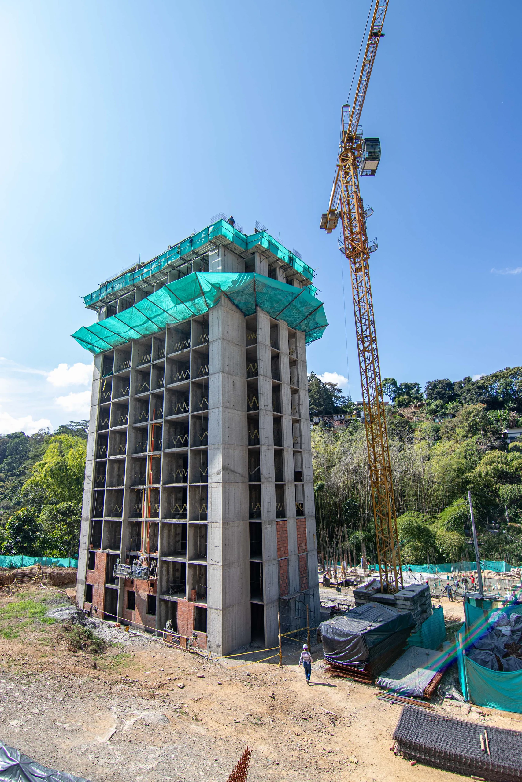 La estructura en concreto asciende ajustada al desnivel del terreno, con el bosque de guadua del Eje Cafetero rodeando la obra.
